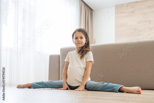 Free Download Little girl doing split in living room at home - GFXLoad
