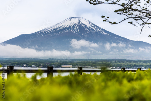 Scenic view of Mount Fuji over lake kawaguchiko Japan during springtime with lush foliage