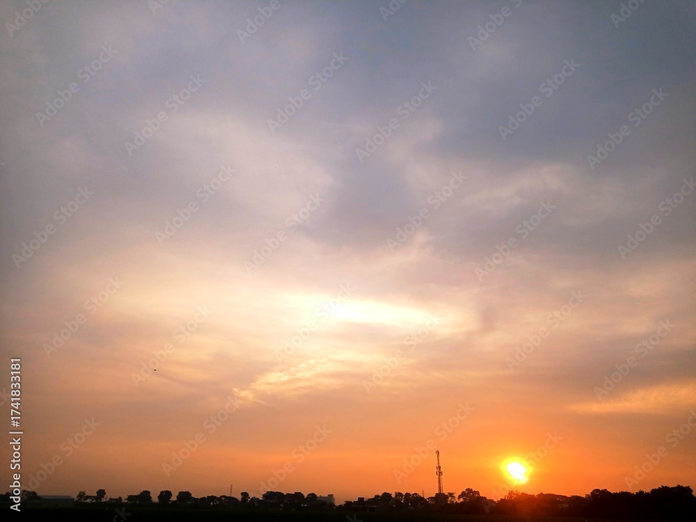Naklejka premium Evening sky, a beautiful sunset with the sun turning yellow in the west and dark clouds, creating a dramatic sky atmosphere