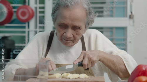Elderly woman are cooking in the kitchen at home, cutting vegetables and baby corn to prepare for a salad.