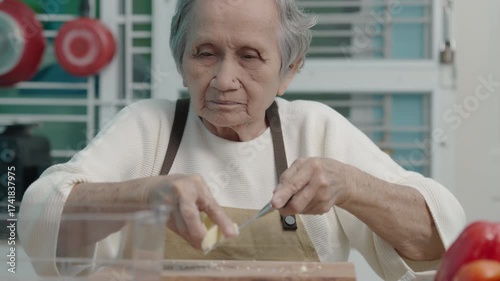Elderly woman are cooking in the kitchen at home, cutting vegetables and baby corn to prepare for a salad.