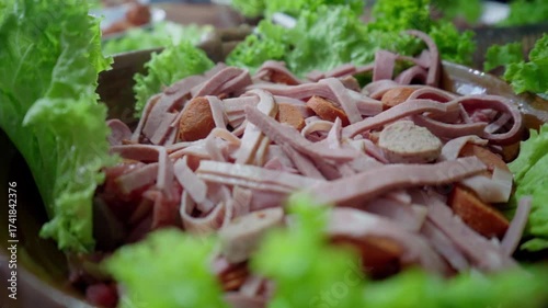 A super-detailed shot of a slow-falling sausage onto a plate of Guatemalan cold cuts.