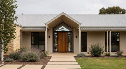 Exterior view of a modern house with a wooden door and a pathway leading to the entrance area