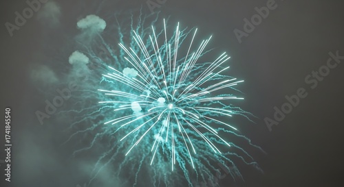 Cyan Fireworks Exploding in the Night Sky Amidst Smoke and Clouds