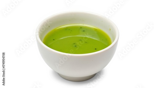 Green soup served in a white bowl on a plain background  