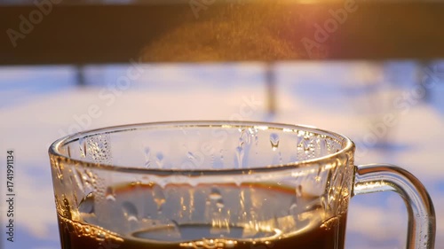 Steaming Coffee Cup in Sunlight with Winter Snow Backdrop