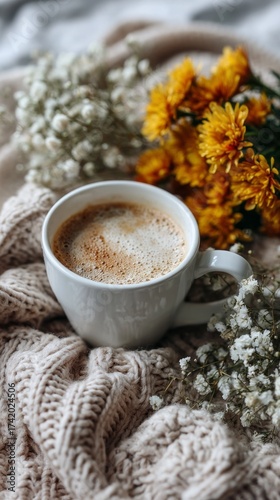 Cozy morning with warm coffee and beautiful flowers on a soft blanket