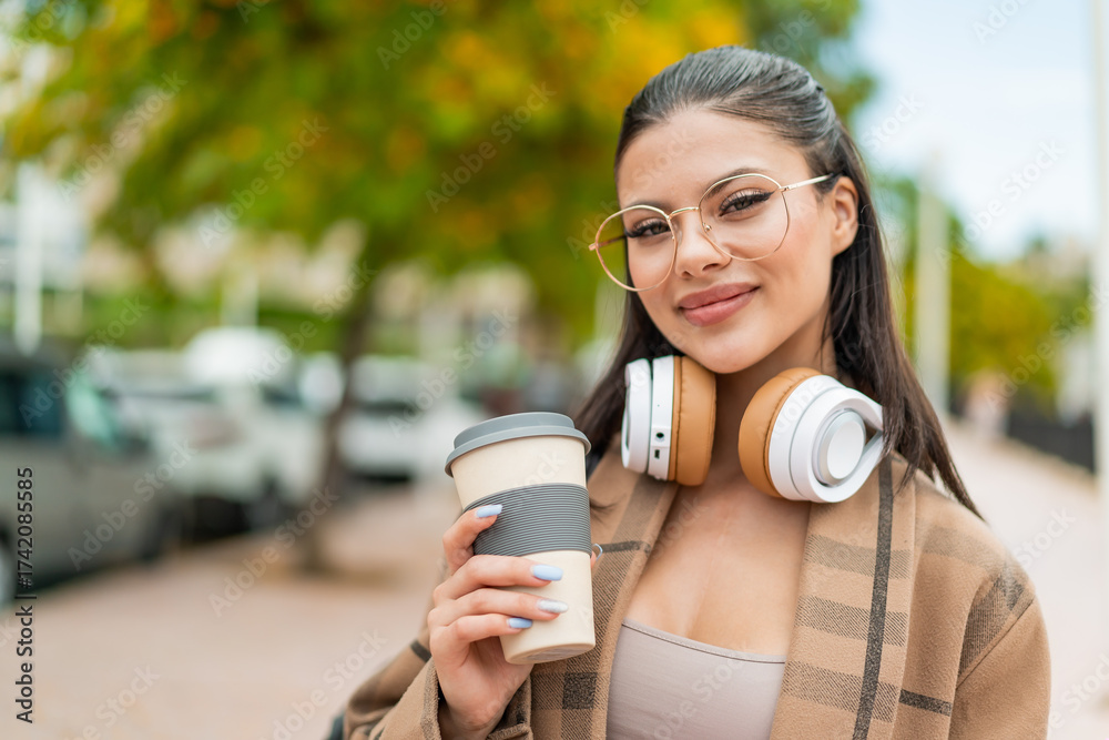 Fototapeta premium Young pretty woman at outdoors with happy expression
