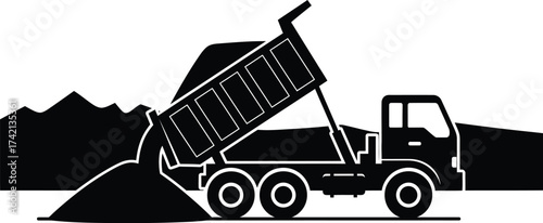 Heavy dump truck unloading gravel on a construction site with mountains in the background