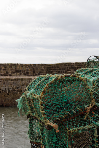Close-up of lobster pots stacked on quay in Scottish harbour