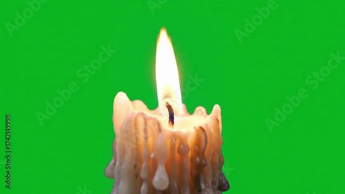 Burning candle with dripping wax against a green screen background.