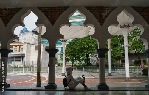 Photography Girl resting at the Jamek Mosque in Kuala Lumpur, Malaysia.