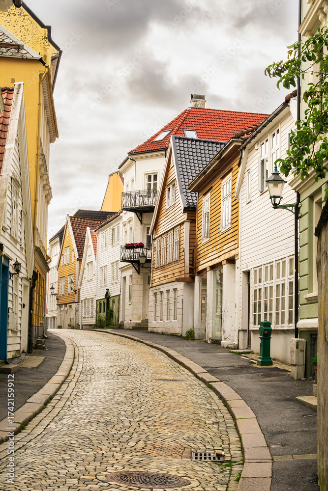 Obraz premium Bergen street featuring colorful traditional wooden houses lining a winding cobblestone road