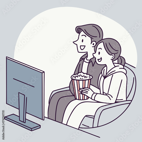 Couple watching TV with popcorn on a sofa and smiling