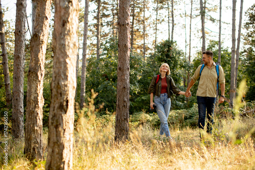 Canvas Print Couple enjoys a peaceful hike together in a serene forest during a sunny afterno
