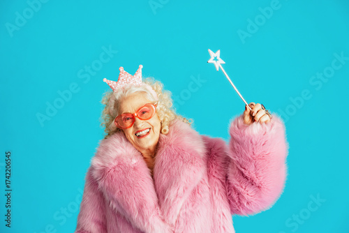 Foto Beautiful senior old woman wearing fancy party clothes acting on a colored backg