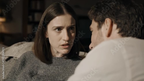Emotional Conversation Between Woman in Gray Sweater and Man in White Shirt in Dimly Lit Interior