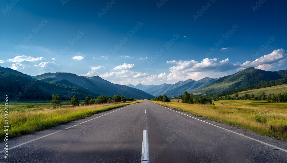 Naklejka premium Long straight highway through green valley and mountains under clear sky, perfect for travel and background concepts