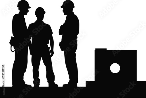 Three construction workers in silhouette conferring outdoors near a building component.