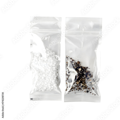 Two transparent plastic bags with white and dark granules isolated