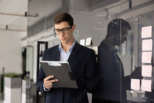 Wallpaper Mural Serious young Latin businessman writing notes in document Torontodigital.ca