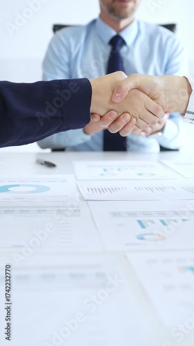 Business handshake agreement in modern office with financial documents, successful partnership deal, teamwork collaboration and corporate negotiation concept