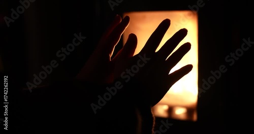 Close up of hands close to oven with glass window and fire inside