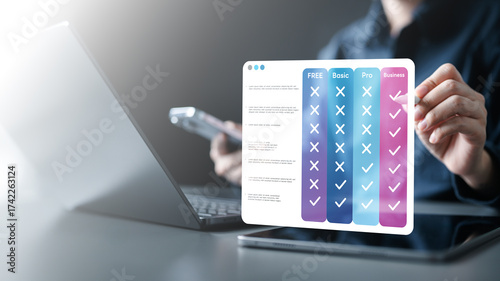 pricing, table, compare, plans, monthly, annual, tiers, Hand using tablet with digital pricing table interface comparing plans, tiers, features, and subscription options for online business services.