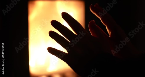 Close up of hands close to oven with glass window and fire inside