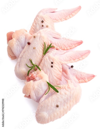 Raw poultry wings arranged with peppercorns and rosemary sprigs