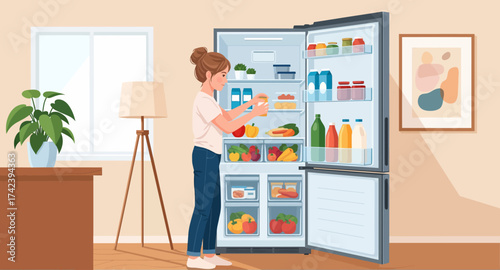 A young woman places groceries on shelves inside a refrigerator, illustrating home organization and kitchen chores.