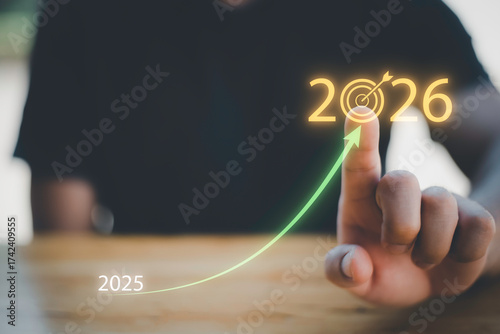 Businessman touching 2026 with arrow target icon, representing new year business goal, strategic planning, vision, annual growth and roadmap for success from 2025 to the future.