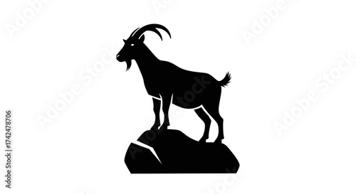 Silhouette of a majestic goat standing proudly on a rock.