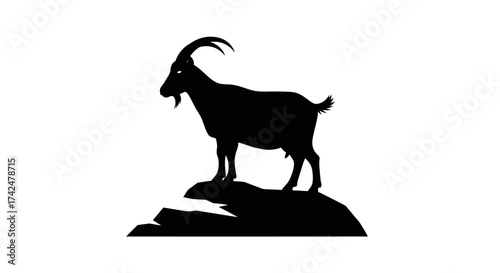 Silhouette of a Majestic Mountain Goat Standing on Rocky Peak.