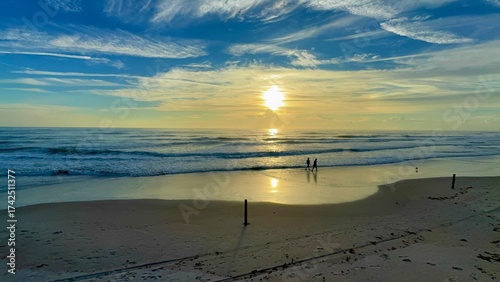 couple walking down a beach at sunrise