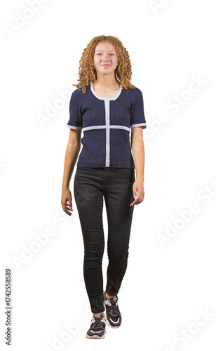 Full length portrait of contented teenage girl with curly hair, walking confident towards camera. Positive frizzy young woman, adolescent portrait isolated on transparent background
