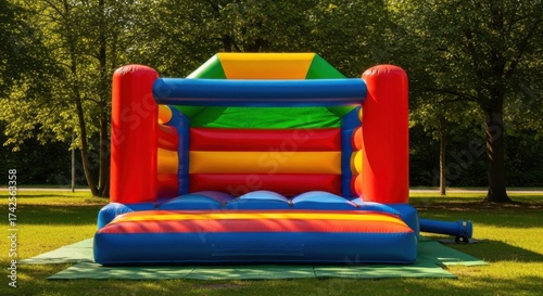 Colorful Inflatable Bouncy Castle in Park with Green Trees and Sunny Weather