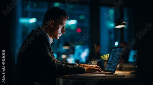 Focused Work in the Late Hour: A determined individual, immersed in deep concentration, works late into the night at a modern computer, bathed in cool artificial light.