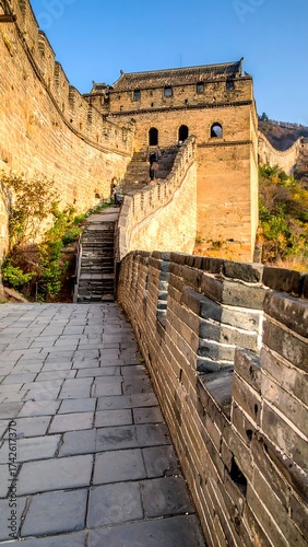 Massive fortification with stairs ascends towards tower in daylight