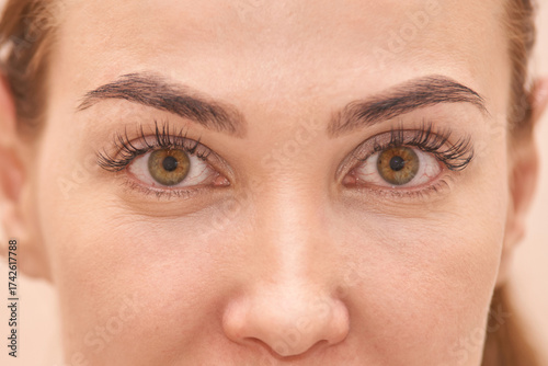 Close-up of young caucasian female with brown eyes and natural eyebrows.