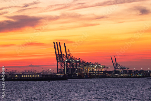 Container terminal with cranes in Hudson Bay at sunset.