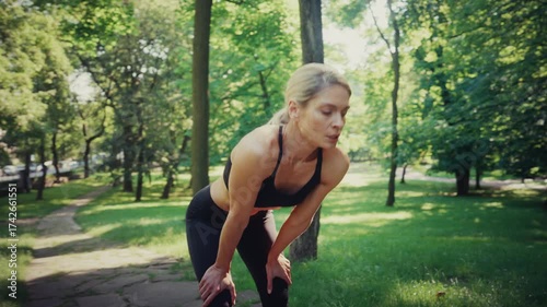 Tired woman catching breath after running in park