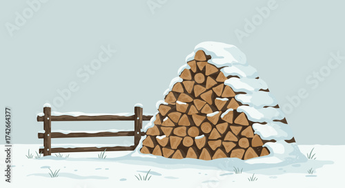 Stacked firewood covered in snow next to wooden fence in winter landscape