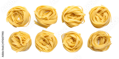 Eight nests of uncooked yellow tagliatelle pasta on black background fettuccine