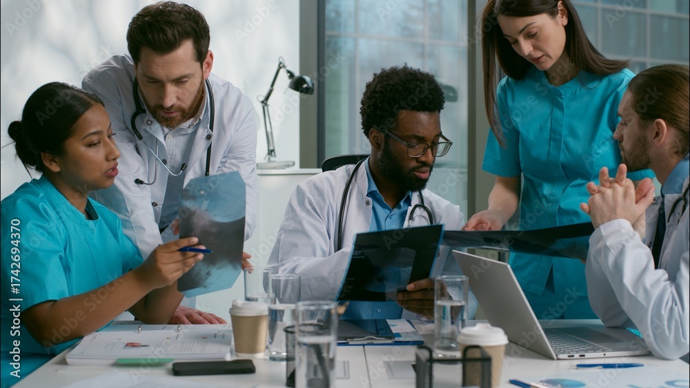 Obraz premium Multiethnic doctors medical diagnostic team meeting heath research xray analyzing African men Indian Caucasian women diverse nurse surgeon medicare five people talk discuss checkup results at clinic