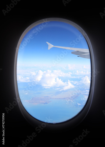 Obraz na płótnie airplane window seeing wing and clouds during intercontinental flight