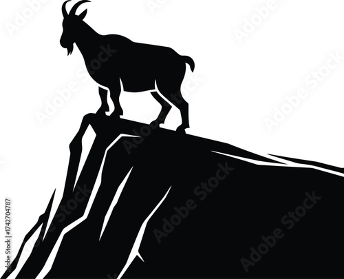 Silhouette of a goat standing on a rocky cliff edge mountain