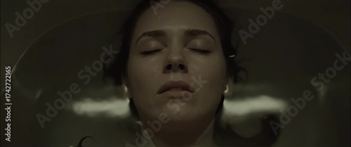 Calm woman submerged in water with eyes closed