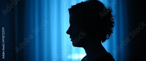 Silhouette of a woman against blue background: mystery and elegance