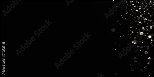 Water drops and splash in motion on a black background with a hint of bright light and smoke